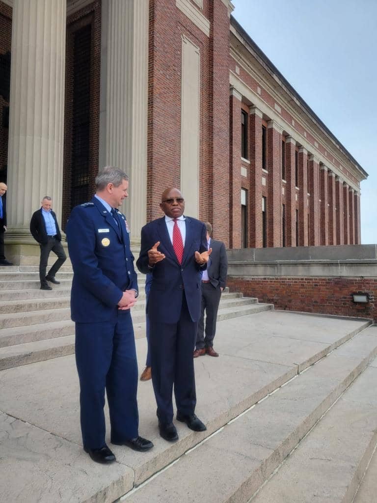 Two men standing together outside a brick building