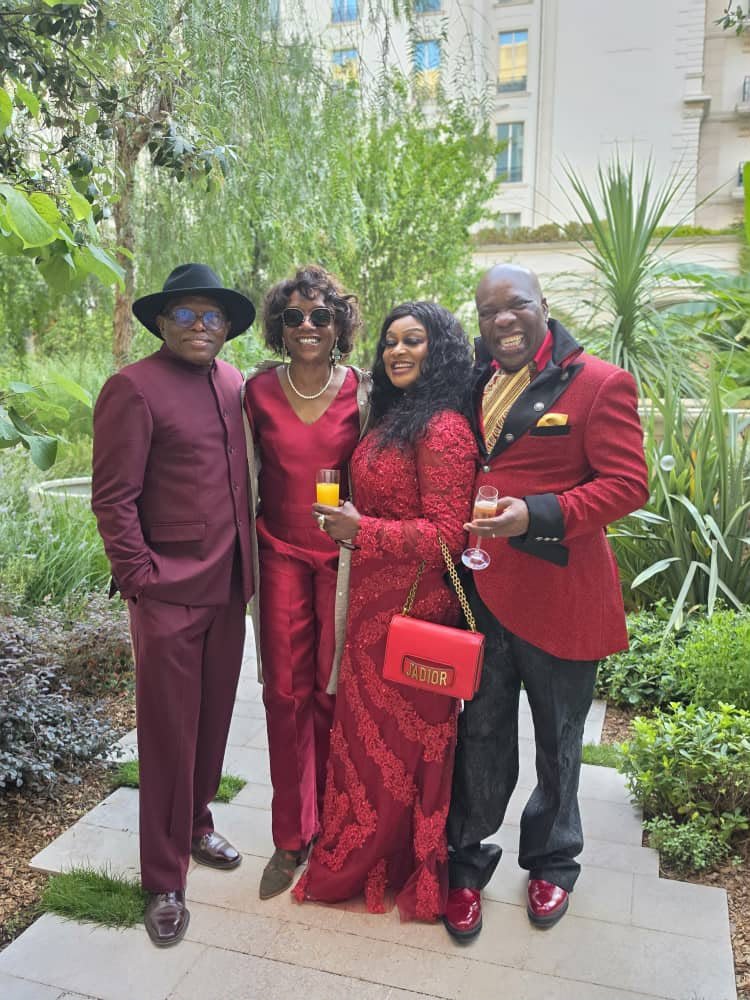 Four people posing together outdoors in formal clothes