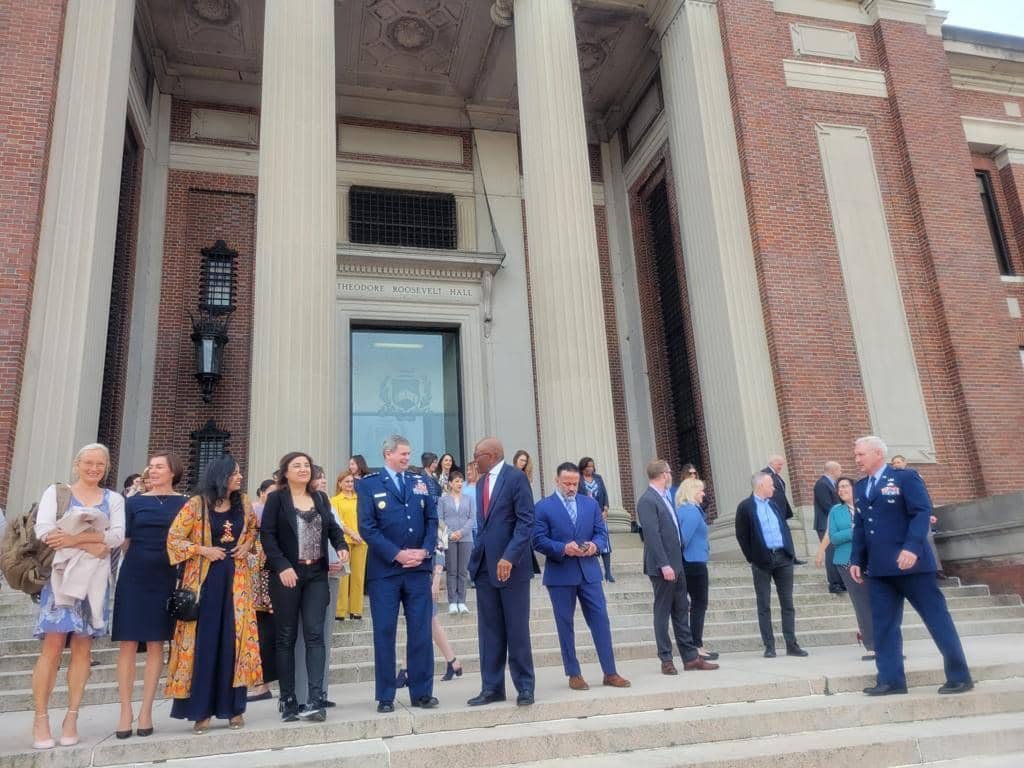 A group of people posing outside a brick building